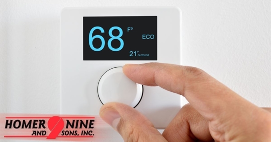 Hand adjusting a thermostat that reads 68 degrees.